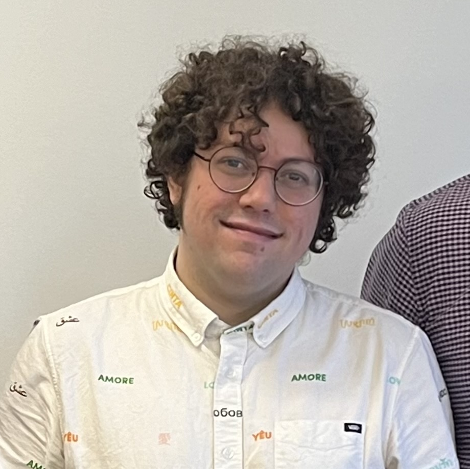 BrettC in a white collared shirt with the word "love" in several different languages on it